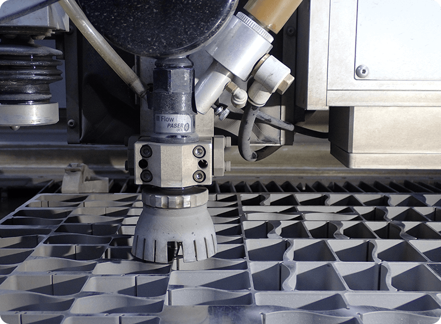 image of nanojet waterjet cutting a sheet of STS